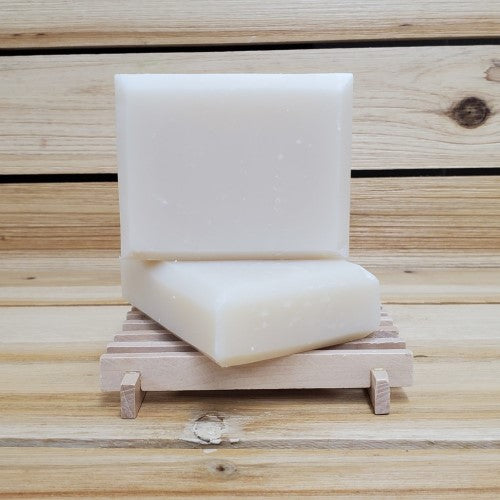 2 bars of bergamot soap on a wood soap dish