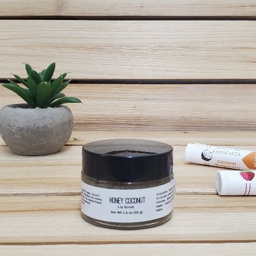 Honey Coconut Lip Scrub next to plant and lip balm closed lid