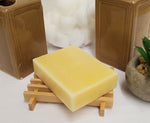 Sweet Cedarwood Soap on wood soap dish next to plant