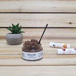 Chocolate Mint Lip Scrub open lid next to plant and lip balm