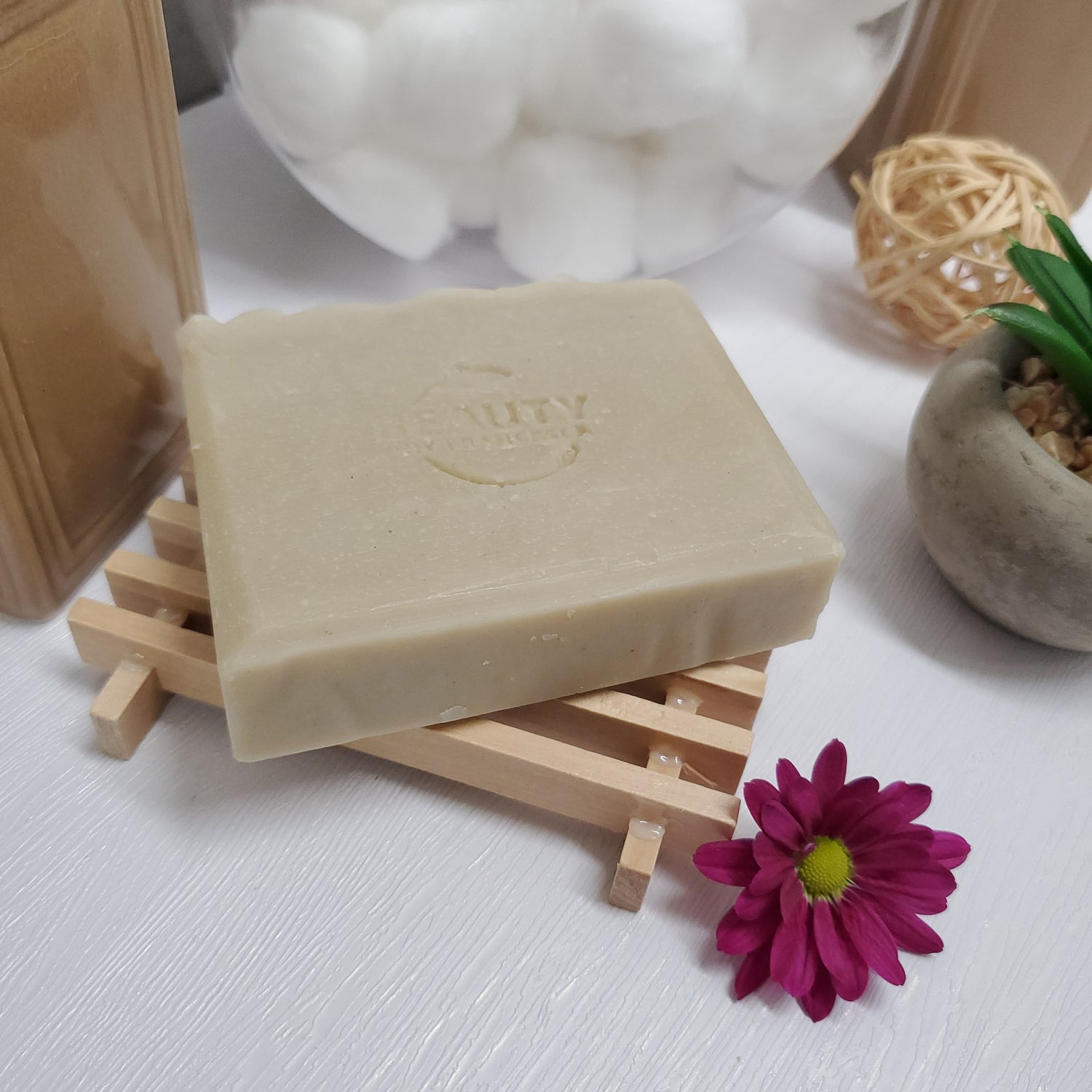 Eucalyptus Handmade Soap on top of wooden soap dish near plant